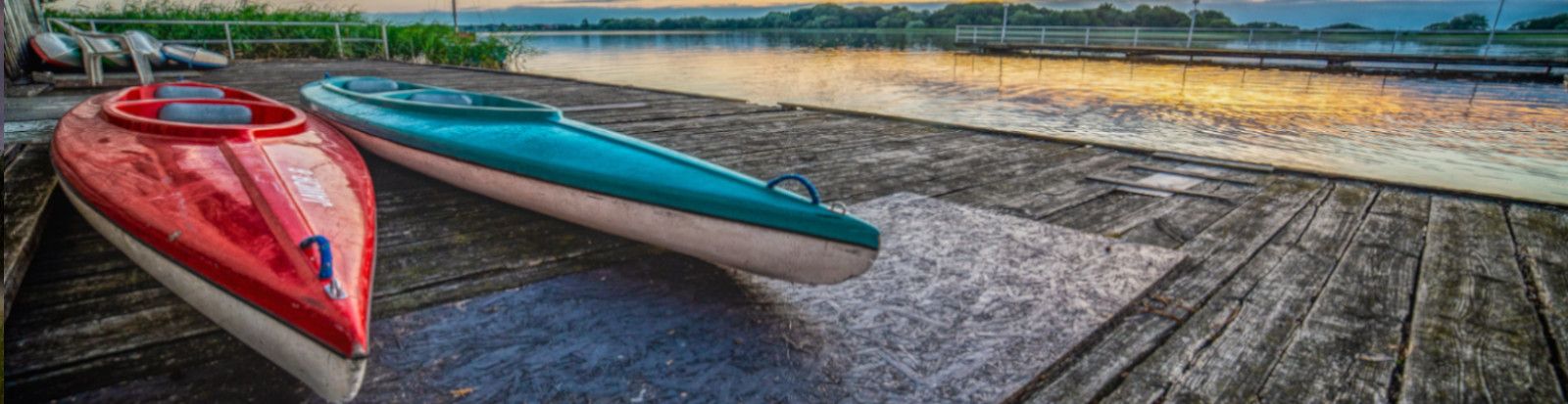 Zdjęcie przedstawia kolorwe kajaki na wodzie